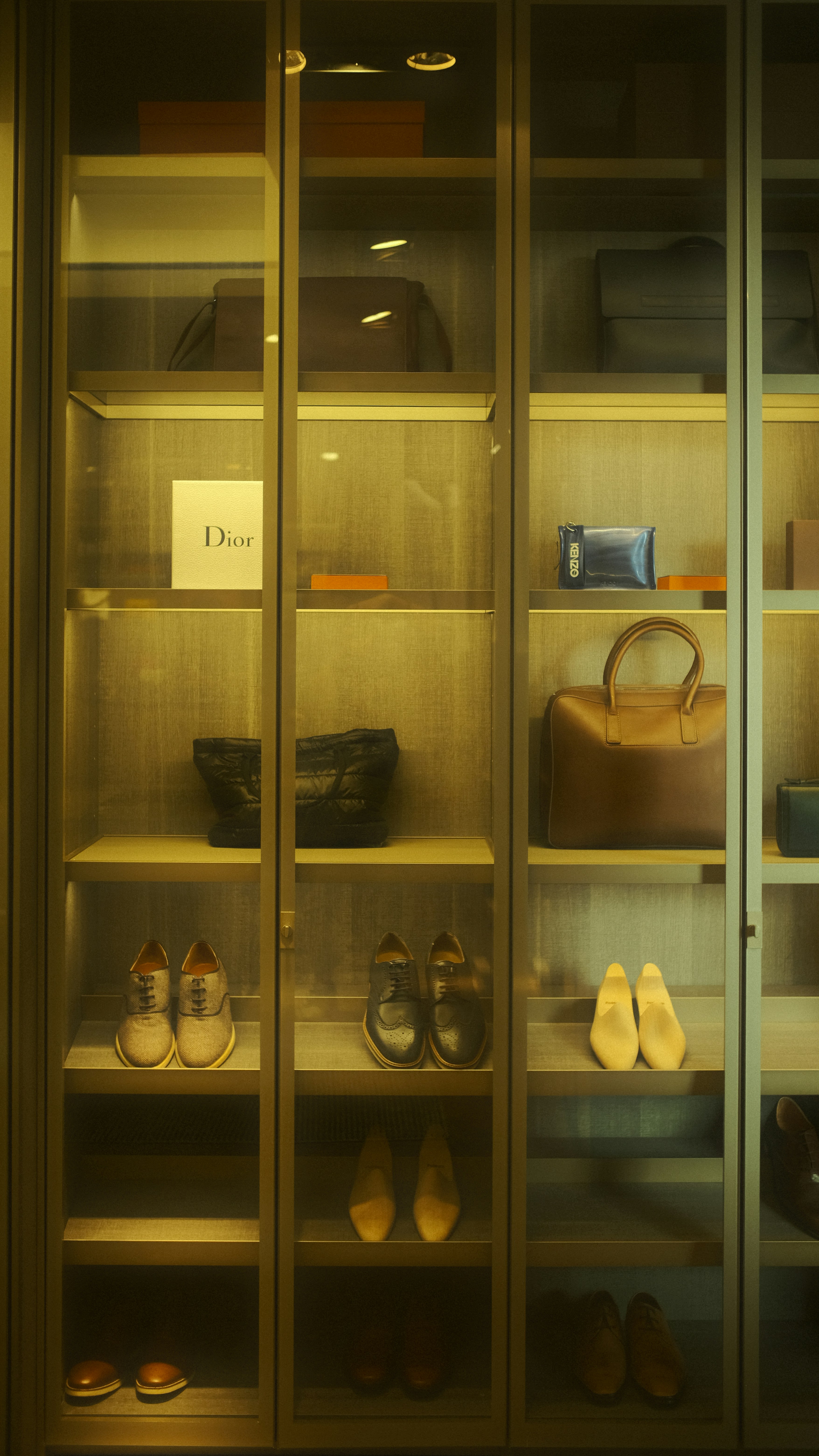 Organized closet with handbags, shoes, and boxes.